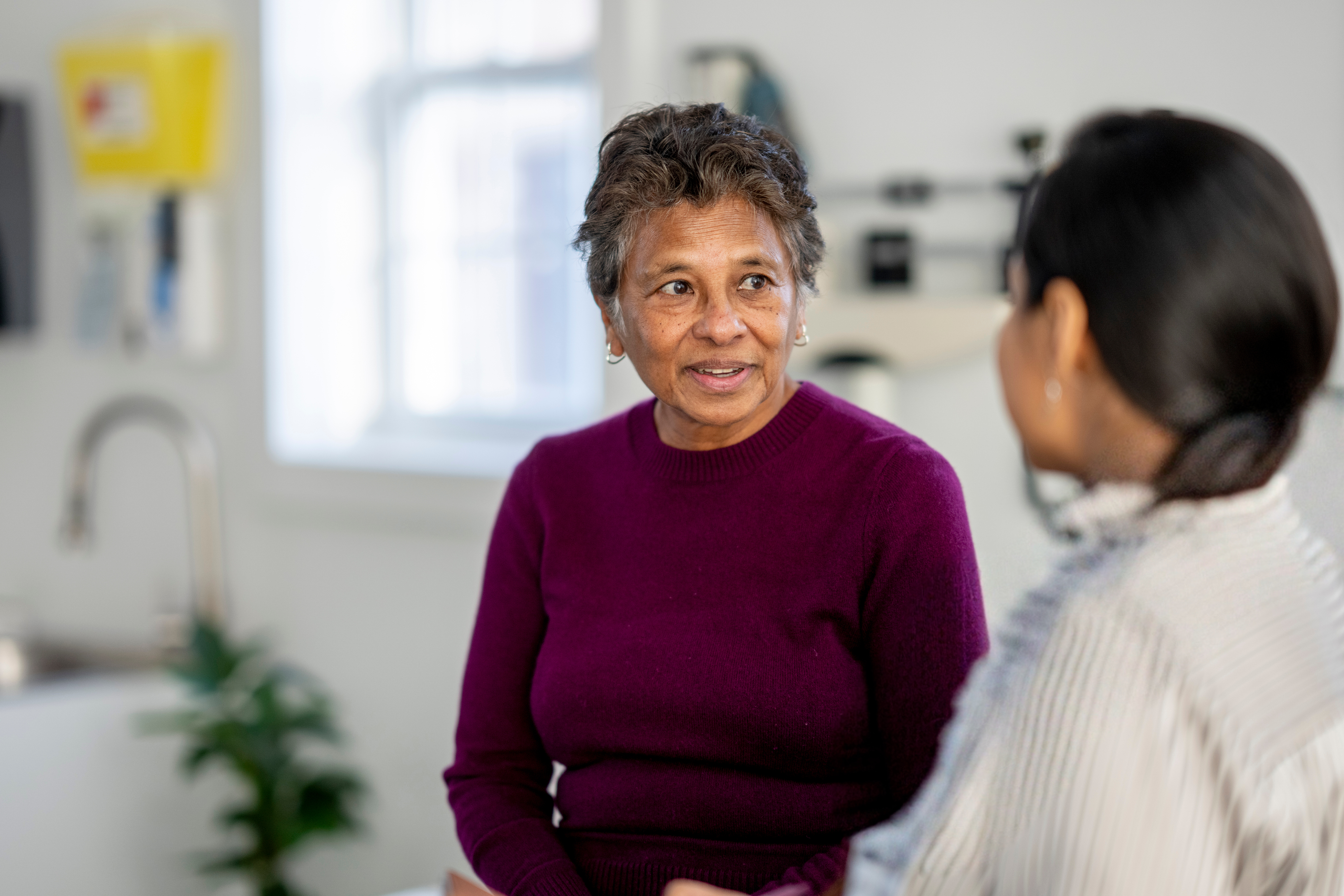 Patient speaking with a healthcare professional during a clinical consultation.